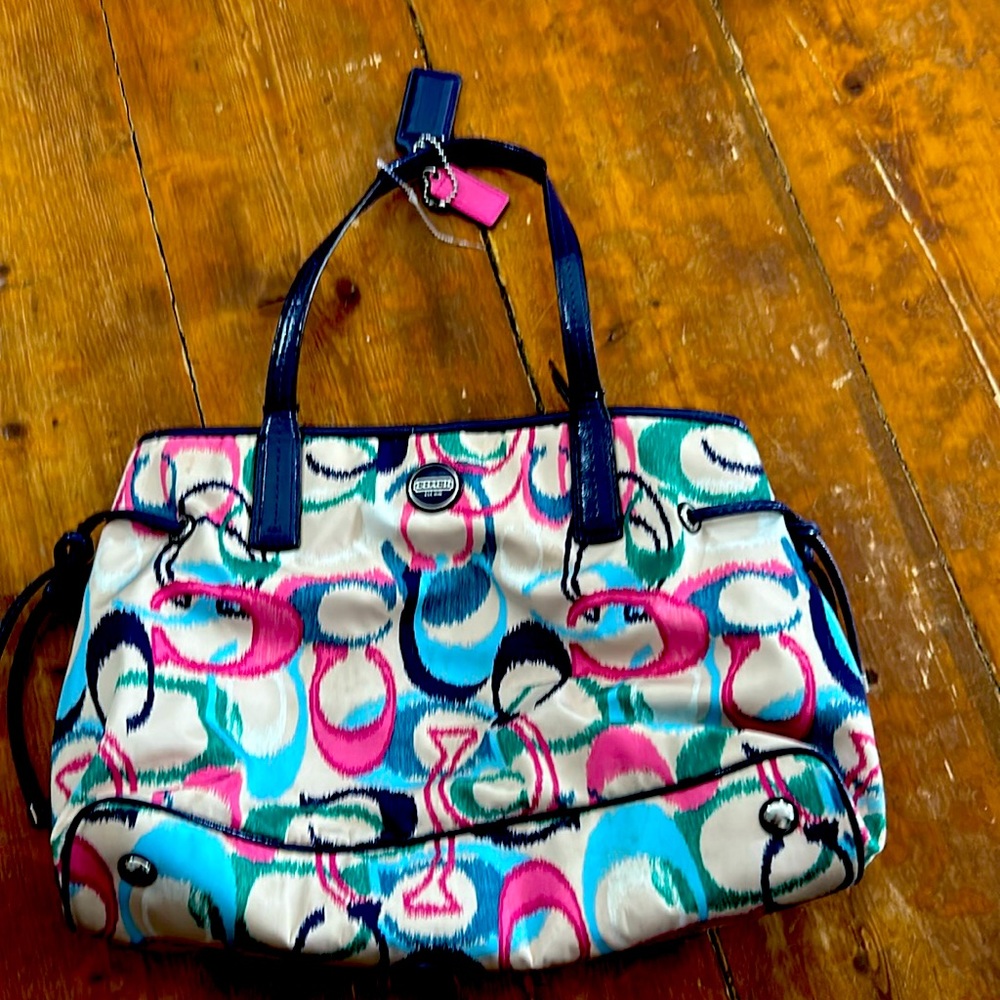 I’m selling a slightly used Coach Blue, Pink, Purple, White Turquoise Logo Purse